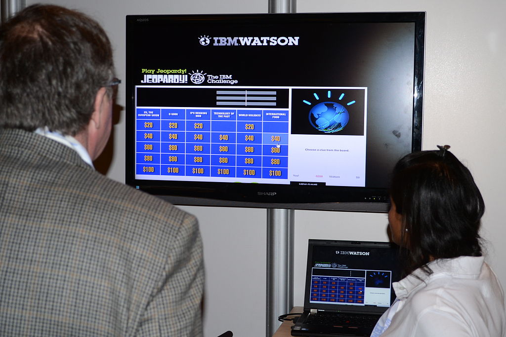 man at computer with IBM Watson on display