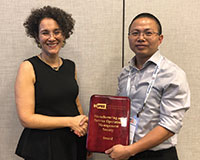 MSOM President Wedad Elmaghraby congratulates Junfei Huang (l-r).
