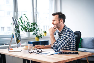 Man smiling at computer screen